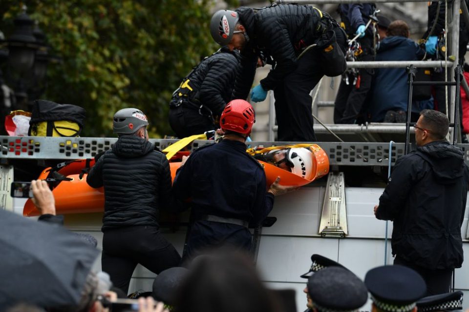 A climate change activist from the Extinction Rebellion group is removed by police from a scaffolding platform in Trafalgar Square in central London, on October 7, 2019 during the group's global climate protests. - Extinction Rebellion has scheduled non-violent protests chiefly in Europe, North America and Australia over the next fortnight. (Photo by Ben STANSALL / AFP) (Photo by BEN STANSALL/AFP via Getty Images)