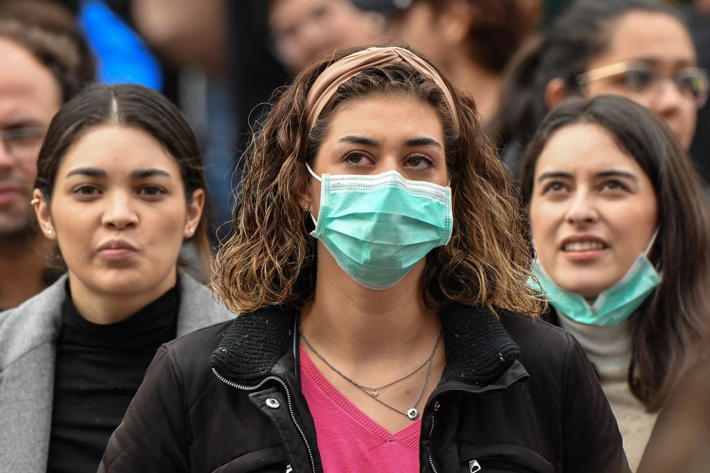 Tourist wearing protective respiratory masks wait near the Vatican amid the Italy lockdown over coronavirus
