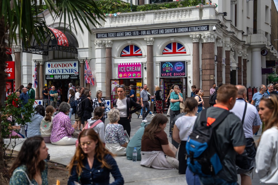 LONDON, ENGLAND - JULY 18: Tourists relax near souvenir, vape and candy shops in Leicester Square on July 18, 2023 in London, England. The proliferation of American-style candy stores in Oxford Street and the surrounding area began in 2017 and increased significantly during the Covid-19 pandemic when well-known shop chains closed down leaving buildings empty. Landlords moved them in rent-free hoping they would pay business rates but many have been prosecuted for non-payment. More recently, trading standards and police have targeted many of the shops and confiscated thousands of pounds worth of counterfeit and dangerous goods. Westminster City Council wrote to the landlords in May begging them to do “all that they can” to bring the influx of the stores to an end. (Photo by Carl Court/Getty Images)