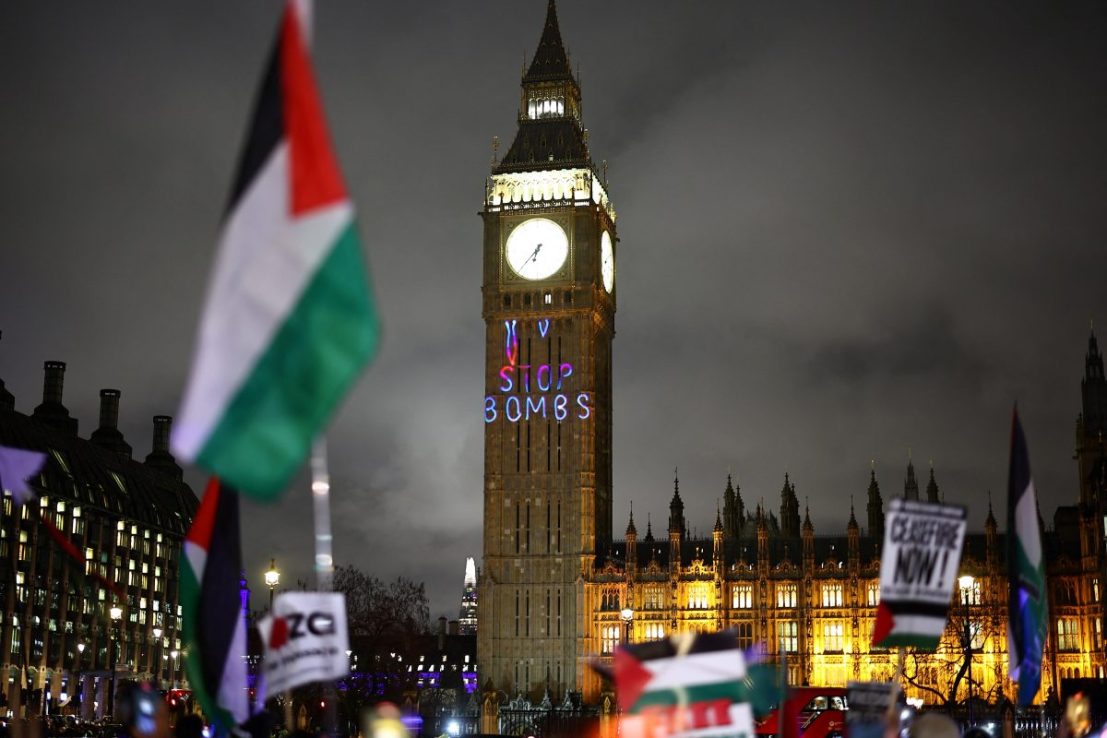 A Palestinian flag flaps in the air by a message reading 