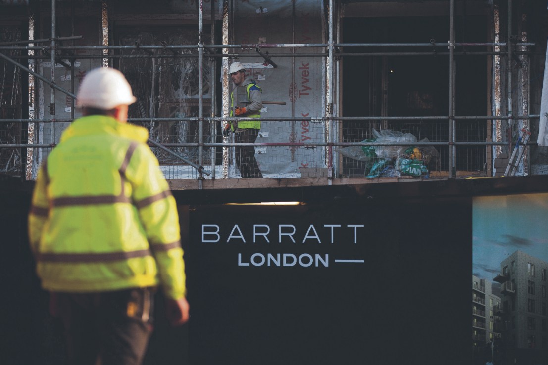 A "Barratt London" logo sits on a sign outside the "Catford Green" residential apartment complex, as it stands during construction by Barratt Developments Plc, in the Catford district of London  Photographer: Simon Dawson/Bloomberg via Getty Images