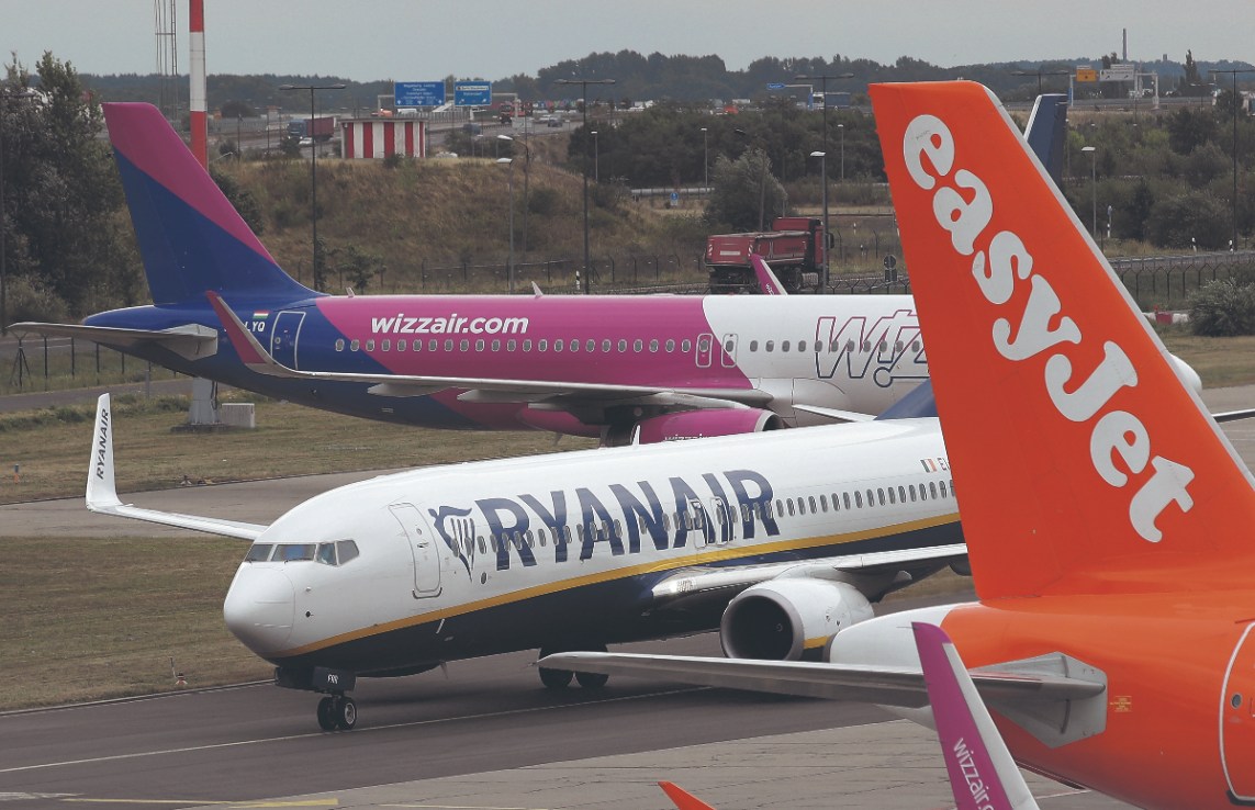 The forecasts from Ryanair, Europe's largest airline by passenger numbers, echo wider industry warnings of downward pressure on ticket prices. (A RyanAir passenger plane taxis past planes of other discount airliners Wizz Air and EasyJet at Schoenefeld Airport.  (Photo by Sean Gallup/Getty Images))