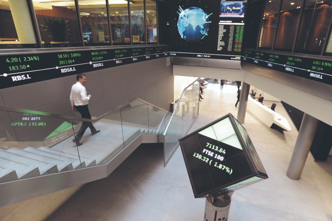 The FTSE 100 reshuffle will likely see Tritax Big Box and Hiscox moving to the main market. (Electronic ticker tape showing the FTSE 100 inside the London Stock Exchange.  (Photo credit should read: Nicholas .T. Ansell/PA Wire))