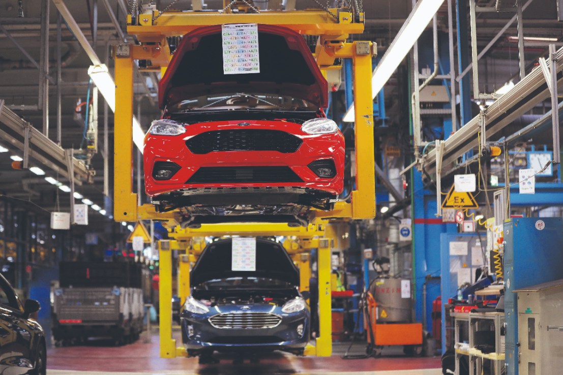 A new Ford Fiesta automobiles hang in cradles on the assembly line at the Ford Motor Co. factory. ( Photographer: Krisztian Bocsi/Bloomberg via Getty Images)