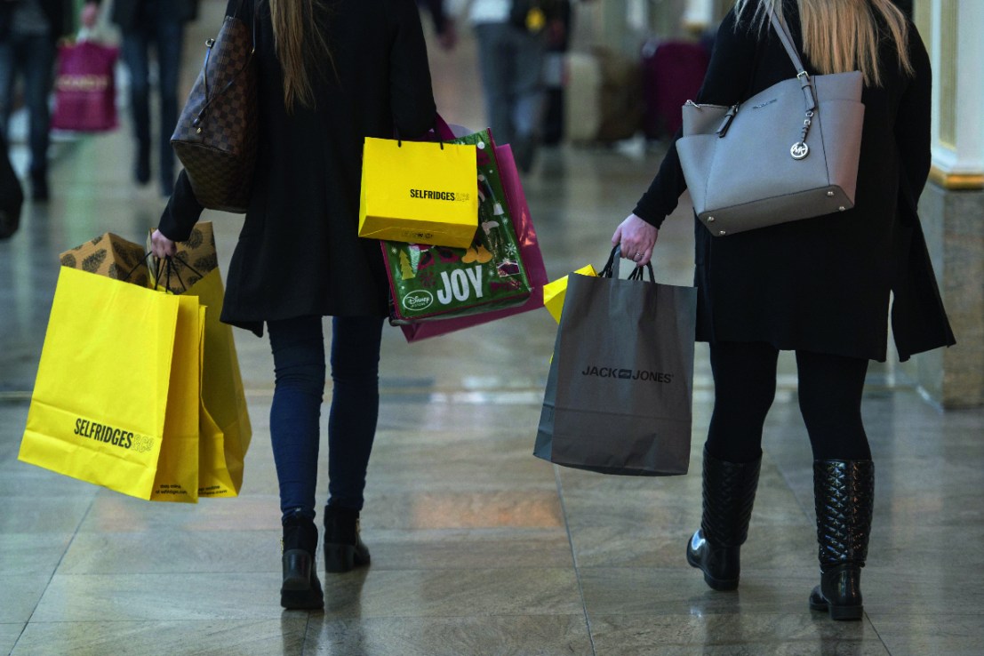 Shoppers carry bags containing purchases from Selfridges and Janck Jones. This Black Friday and Christmas, many Brits will be going local instead.  AFP / Oli SCARFF        (Photo credit should read OLI SCARFF/AFP/Getty Images)