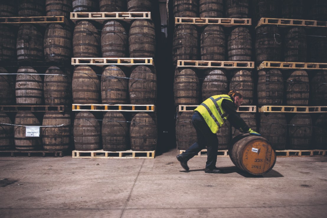 Workers fill casks that will be stored at the distillery  for a minimum of three years before the product can be called Scotch Whisky at the whisky Annandale Distillery, in Annan, in Dumfries and Galloway, in Scotland.  (Photo by Andy Buchanan / AFP) (Photo by ANDY BUCHANAN/AFP via Getty Images)