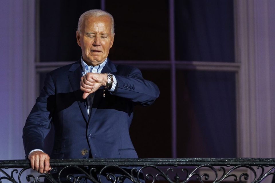 WASHINGTON, DC - JULY 04: President Joe Biden checks his watch as he steps out onto the balcony of the White House to view the fireworks over the National Mall during a 4th of July event on the South Lawn of the White House on July 4, 2024 in Washington, DC. The President is hosting the Independence Day event for members of the military and their families. (Photo by Samuel Corum/Getty Images)