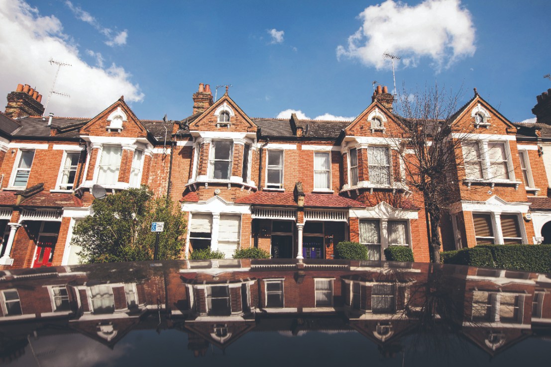 The roof of a parked automobile reflects a row of residential properties in the Battersea area of London,   Photographer: Jason Alden/Bloomberg via Getty Images