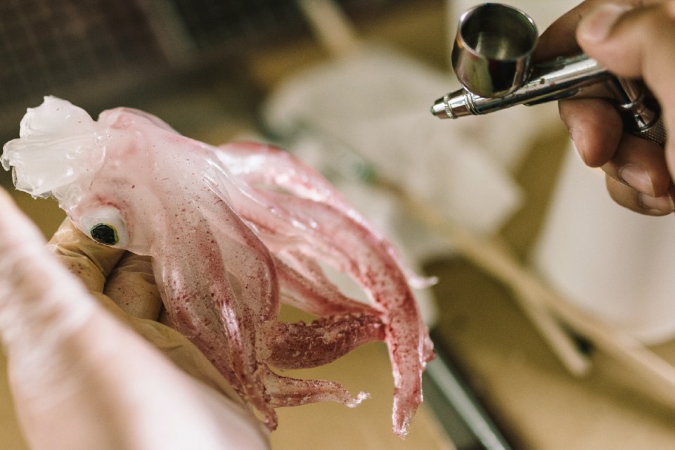 A man airbrushes a squid, an example of Japanese model food