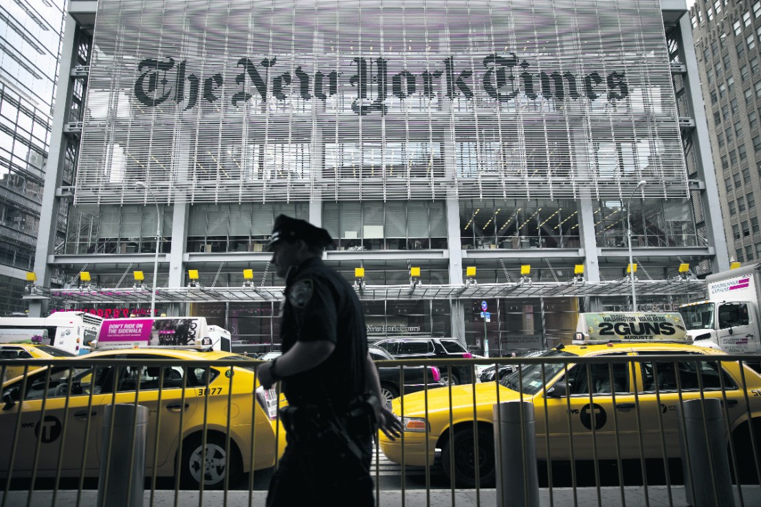 An New York City Police Department (NYPD) police officer passes in front of The New York Times Co. offices in New York, U.S. (Photographer: Scott Eells/Bloomberg via Getty Images)