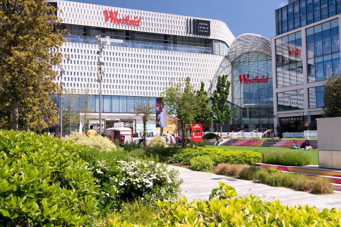 The company behind the Westfield shopping centres in London has reduced its pre-tax loss.